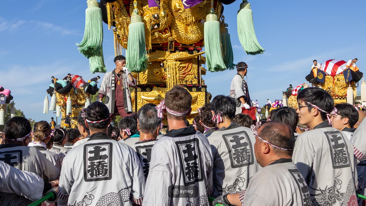 Bearers looking up at taiko float with gleaming golden decorations